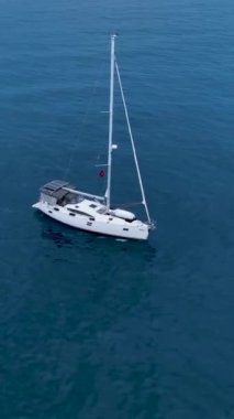 Bu dikey videoda dramatik bulutlu bir günbatımında beyaz bir yat limanda dolaşırken görkemli bir kış yelkenlisine binin. Sahnenin sinematik güzelliğine tanık olun..