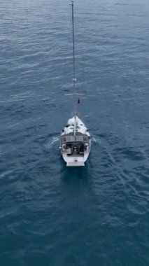 Bu dikey videoda bir yelkenlinin limana yavaşça açıldığı huzuru hissedin. Muhteşem derin deniz arkaplanına ve anın sükunetine hayran olun..