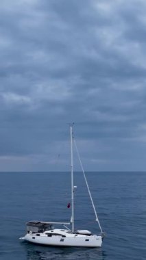 Bu dikey videoda, görkemli bir derin mavi denizdeki limana huzur içinde giren bir yat yolculuğuna binin. Sinema güzelliğini kuş bakışı perspektiften yakala.