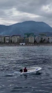 Teknedeki bir balıkçının balık tutması ve kıyıya yakın bir yerde kulaklıkla müzik dinlemesi gibi dramatik titreşimleri deneyimleyin..