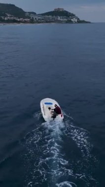 Balıkçı balıkçılık sanatı ile kulaklıklarıyla çalan dramatik film müziğini birleştirirken teknedeki serenata tanık olun. Bu dikey video onun yeteneğini ve tutkusunu gösteriyor..