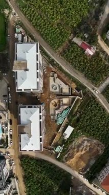 Bu dikey videoda yapı iskelesi için metal çubuklar indirilirken inşaat sürecinden haberdar olun.