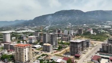 Dikey dönüşümü, işçilerin hayret verici bir hava görüntüsüyle özenle ticari kompleks çatıyı su geçirmez hale getirerek tecrübe edin..