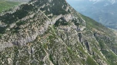 Muhteşem bir orman ve sakin bir köyün nefes kesici güzelliğine dalın, yeşillik tarafından kucaklanmış, büyüleyici bir hava perspektifinden bakın..