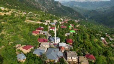 İnsansız hava aracı, yolcuların yolculuklarının başarıyla sona erdiği sakin bir dağ köyünün ürkütücü hava perspektifini ortaya çıkarırken zümrüt cenneti deneyimleyin..