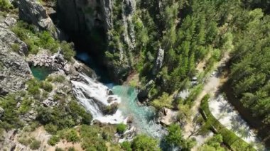 Şelalenin turkuaz heybetli şelalesiyle hayranlık uyandıran bir hava karşılaşmasına binin. İnsansız hava aracı, çağlayan güzelliğini zıt beyaz köpükle yakalar ve büyüleyici bir görüntü yaratır..