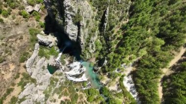 Sakin şelalenin dinginliğini hava perspektifinden hissedin. İnsansız hava aracı, ışıldayan turkuaz suların ve köpüklü beyaz şelalenin harmonik karışımını ortaya çıkarıyor..