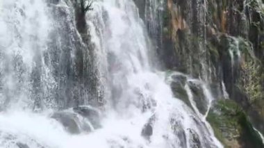 Türkiye 'nin Antalya kentindeki popüler şelalenin büyüleyici güzelliğine dalın, yukarıdan görüldüğü gibi, su hızla düşüyor, göz kamaştırıcı bir serpinti serpintisi sergiliyor..