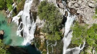 Gökyüzü sularının ihtişamını yakalayan sinematik dronun yeşil bir ormandaki görkemli şelalenin büyüleyici hava keşfine çıkın.