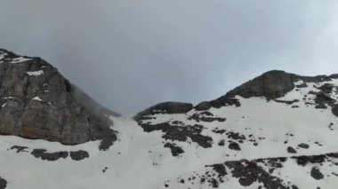 Dağların ve bulutların büyüleyici havadan görünüşünden haz alarak zarif bir şekilde dans ederek büyüleyici bir manzara yaratır..