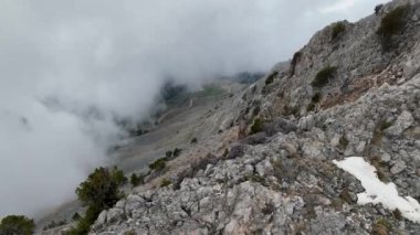 Kendinizi sinematik mucizeye daldırın. Dağlar ve bulutlar canlı renklerin ahenkli bir görüntüsüyle bir araya gelir..