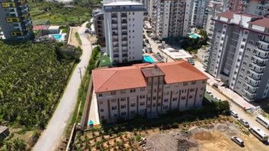 İHA, çocukların açık okul bahçesinde enerjik bir şekilde koşup oynadığı bir Türk ortaokulunun havadan görüntüsünü sağlarken canlı atmosferi yakalayın..