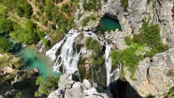 緑の森に囲まれた壮大な滝の息をのむような空の景色を提供するドローンとして観光客を魅了する夢のような美しさを目撃してください — ストック動画
