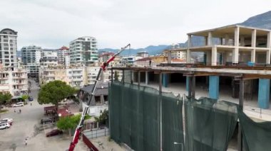 Binaların kuş bakışı görüntüsünü alın. İnsansız hava aracı, çatı takviyesi için yüklenen metal kirişlerin hava perspektifini yakalar..