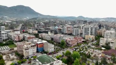 Deniz kıyısındaki patlamanın büyüleyici bir hava perspektifi sayesinde büyüleyici sahil kasabasının hızlı gelişimini gözler önüne seriyor.
