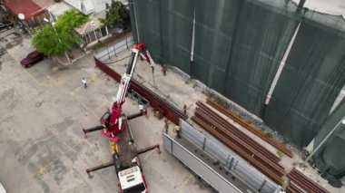 İHA, alışveriş merkezinin çatısındaki kaynaklama faaliyetlerinin havadan görüntüsünü alırken, demir üretiminin karmaşık sürecini gözler önüne seriyor..