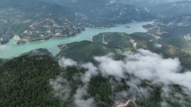 İlahi manzaranın dingin güzelliğine tanık olun. İnsansız hava aracı heybetli dağlarla hayranlık uyandıran bir hava manzarasını gözler önüne seriyor.