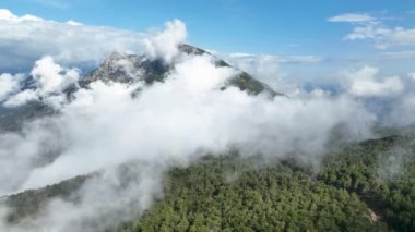 İnsansız hava aracı büyüleyici bir hava perspektifi sunarken, sisli tepelerin cazibesini keşfetmek dağ manzarasının ihtişamını ortaya çıkarır.