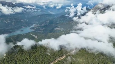İnsansız hava aracı sizi görkemli dağ boyunca büyüleyici bir hava yolculuğuna çıkarırken bulutlarla sarılı ihtişamı keşfe çıkın.