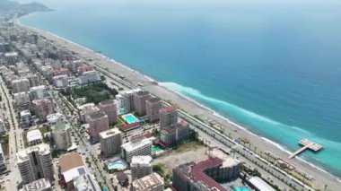 Büyük dalgaların kayalık sahili dövdüğü ve turistleri daha çekici hale getirdiği bir inşaat alanının havadan görüntüsünü deneyin.