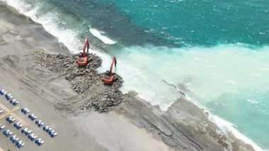 Dalgacıların faaliyet gösterdiği, bölgeyi canlandırdığı ve turistler için daha cazip hale getirdiği bir deniz kenarı şantiyesinde hava araştırması yapın..