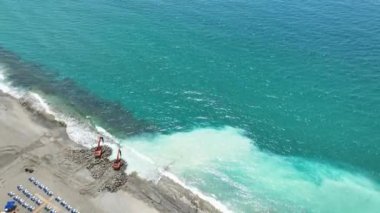 Sahilin güzelliğini, etkili şalterlerin turistler için davetkar bir ortam yarattığı büyüleyici bir inşaat alanının görüntüsüyle gözler önüne sermek.