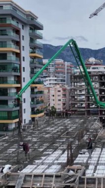 İşçiler çok katlı bir inşaat alanında yeni bir zemin dökerken yukarıdan bakın..