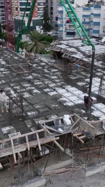 İşçiler yeni bir kat dökerken, çok katlı bir inşaat sahasında kaydedilen ilerlemeye tanık olun..