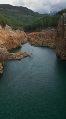 Türkiye 'nin güneyinde bir dağ gölünün ihtişamı, manzaralı kayalık kıyılar ve gelişen çiftçiliğin keyfini çıkarın..