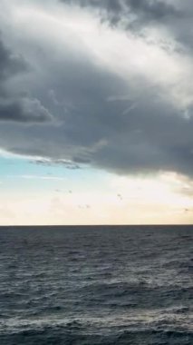 Dikey videoda gösterilen büyüleyici hava görüntüsünde Akdeniz 'in üzerinde sakin bulutlu bir günbatımının gizemini keşfedin..