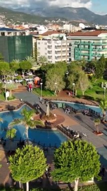 Türkiye 'nin Alanya kentindeki hava manzarasına şahit olduğunuz gibi, deniz kenarındaki oyun parkının tadını çıkaran çocukların dingin sükunetine tanık olun..