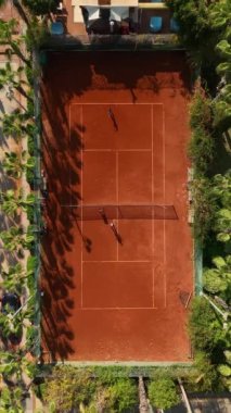 Tenis müsabakalarının heyecanı, yukarıdan çekilen bir cennette, avuçlarla çevrili bir kortta oynanıyor..