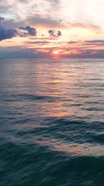 Şok edici bir günbatımının ortasında canlı dalgaların ve büyüleyici bir deniz dalgasının dokusunun zevki..