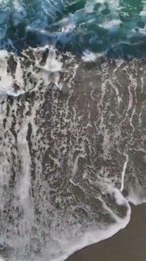 Akşam gökyüzü manzaralı taşlı bir sahil, denizin karmaşık dokusunu yakalıyor..