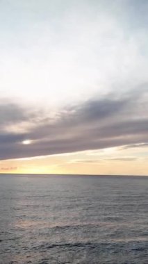 Türkiye 'nin Alanya kentindeki gök mavisi plajlarda ve bulutlu hava bulutlu günbatımına tanıklık ederken, kıyı güzelliğinin sinemasal deneyimine adım atın..