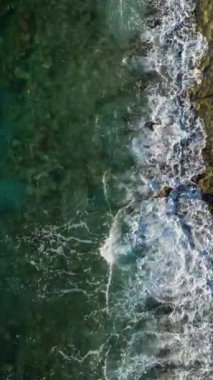 Taşlı bir plajın üzerindeki hava manzarası, deniz desenleri çok güzel görünüyor..
