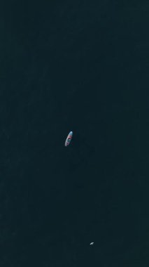 Gün batımındaki bir SUP seansının dinginliğine dalın. Sportif bir çift suda huzur içinde sürükleniyor, büyüleyici bir hava manzarası sağlıyor..