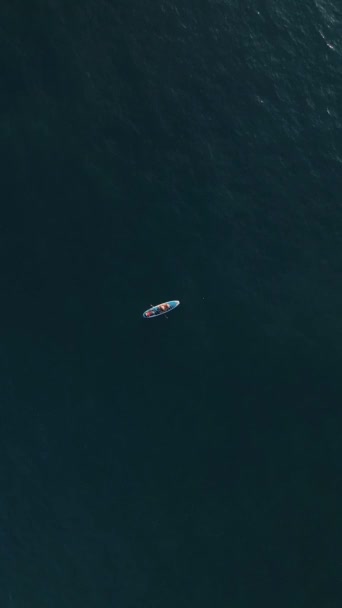 刺激的な空中の視点から捉えられた 日没時に水の上でSup冒険を楽しむスポーティーカップルの興奮を体験してください — ストック動画