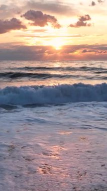 Ağır çekimde büyüleyici fırtınalı ahududu gökyüzünün canlı bir okyanus gün batımını görüntülemesine tanık olun..