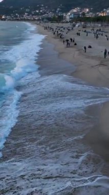 Türkiye 'nin Alanya kentindeki masmavi deniz plajında sörfçülerin canlı enerjisini ve büyüleyici bulutlu günbatımını havadan seyretmenin sevinci.