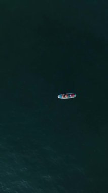 Bir SUP inzivasında huzur bulun. Gün batımında, bir çift huzur içinde suda sürüklenirken yukarıdan sakin bir manzara sağlayın..