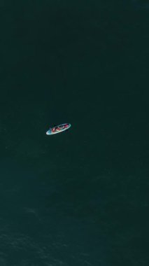 Gün batımında denizde süzülen bir çift olarak kendinizi SUP cennetine daldırın, büyüleyici bir hava perspektifi sunarak.