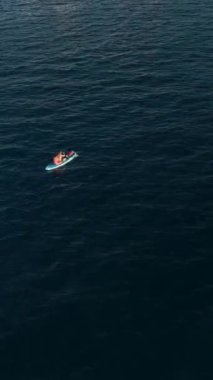 Kendinizi SUP cennetine daldırın sportif bir çift gün batımında denizde süzülüyor, büyüleyici bir hava perspektifi sunuyor.