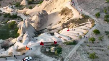 hot air balloons fly over the mountainous landscape of Cappadocia, Turkey. Aerial view