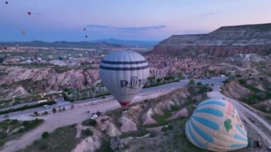 hot air balloons fly over the mountainous landscape of Cappadocia, Turkey. Aerial view