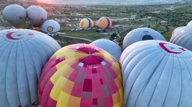 hot air balloons fly over the mountainous landscape of Cappadocia, Turkey. Aerial view