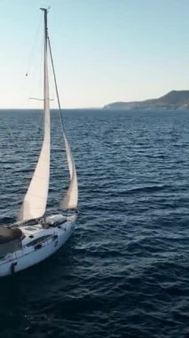 Bir yat serüvenine binerken sinematik bir dron bu dikey videoda nefes kesici bir Akdeniz limanına gelişini yakalar..