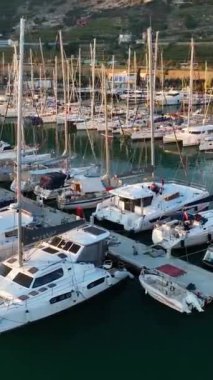 Limanın üzerinden yükselin ve Alanyas limanının manzarasına hayran olun. Zarif yatlar huzur içinde kenetlendi. Bu dikey videoda havadan çekilmiş görüntüler var..