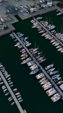 Günbatımında Alanyas limanına yanaşan yatların sinematik görüntülerini bu dikey videoda hava perspektifinden görüntüleyin..