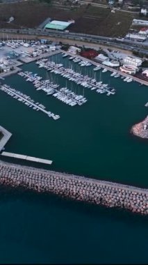 Bu dikey videoda sergilenen çarpıcı bir günbatımı arka planına karşı yatları olan Alanyas limanına eşsiz bir hava perspektifi kazandırın..
